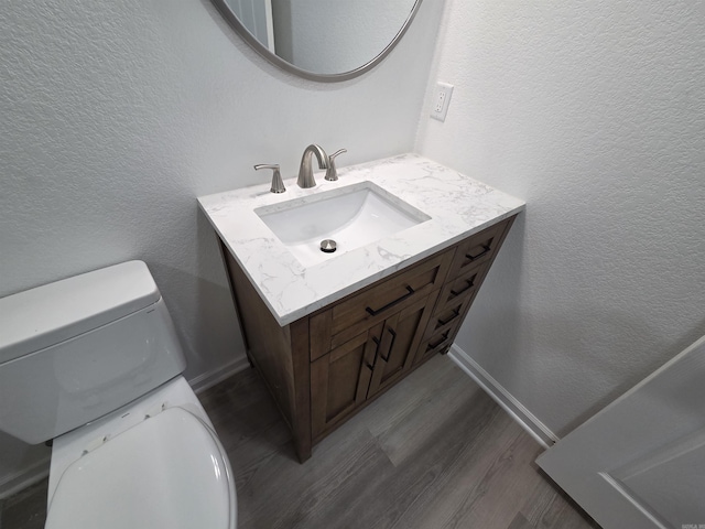 4518 W 25th, Little Rock, AR 72204 - half bathroom with vanity, toilet, wood finished floors, and a textured wall
