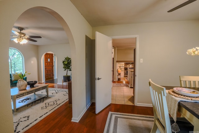 2318 Breckenridge Dr, Little Rock, AR 72227 - dining space featuring a ceiling fan, arched walkways, wood finished floors, and baseboards