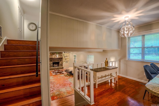 2318 Breckenridge Dr, Little Rock, AR 72227 - stairway featuring wood finished floors, a chandelier, crown molding, a stone fireplace, and baseboards