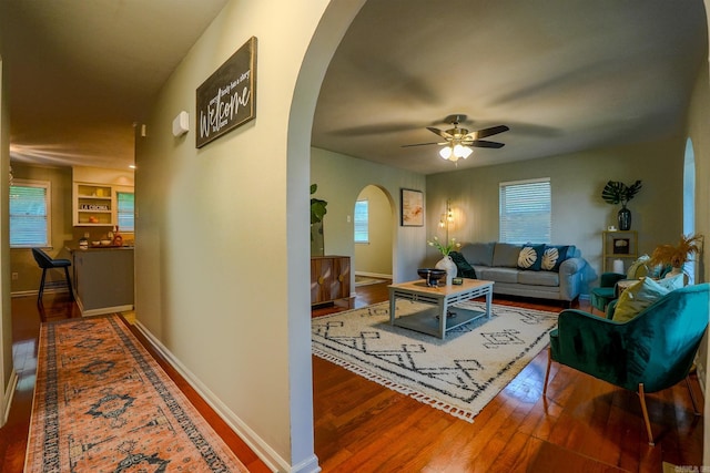2318 Breckenridge Dr, Little Rock, AR 72227 - living room featuring arched walkways, wood finished floors, ceiling fan, and baseboards