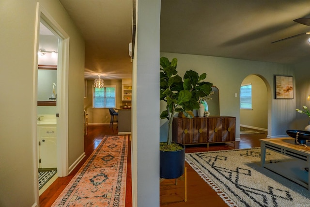 2318 Breckenridge Dr, Little Rock, AR 72227 - hallway with wood finished floors, arched walkways, baseboards, and a sink