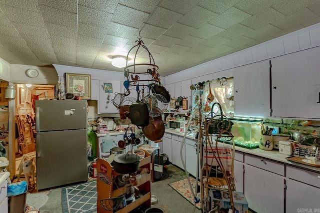 1788 Weatherstone Rd, Mammoth Spring, AR 72554 - kitchen with freestanding refrigerator, white cabinetry, and light countertops