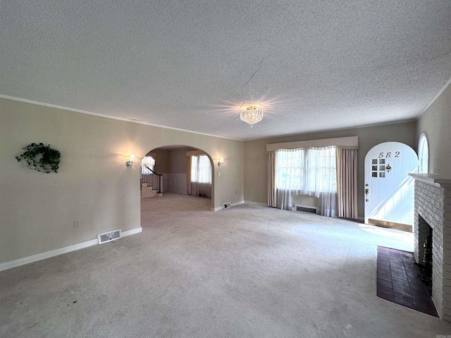 582 N Fourth Ave, Piggott, AR 72454 - unfurnished living room featuring arched walkways, a textured ceiling, carpet flooring, baseboards, and stairs