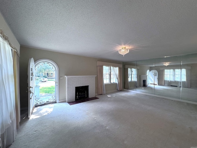 582 N Fourth Ave, Piggott, AR 72454 - unfurnished living room featuring a fireplace, a textured ceiling, plenty of natural light, and arched walkways