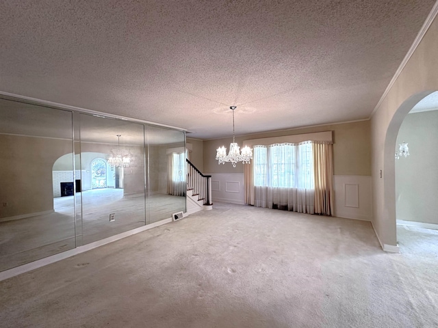 582 N Fourth Ave, Piggott, AR 72454 - unfurnished dining area with a chandelier, arched walkways, a textured ceiling, healthy amount of natural light, and a decorative wall