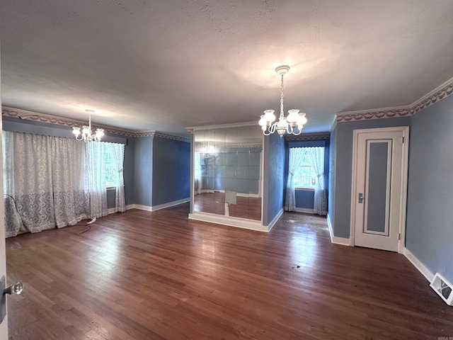 582 N Fourth Ave, Piggott, AR 72454 - spare room with a chandelier, baseboards, ornamental molding, and dark wood-style flooring