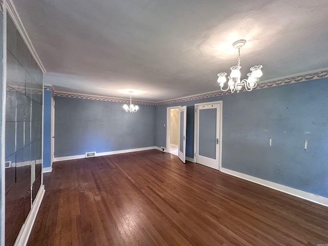 582 N Fourth Ave, Piggott, AR 72454 - empty room featuring a chandelier, dark wood-type flooring, ornamental molding, and baseboards