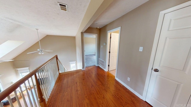 3805 Irby Dr, Conway, AR 72034 - corridor with light wood-type flooring, lofted ceiling, an upstairs landing, baseboards, and a textured ceiling
