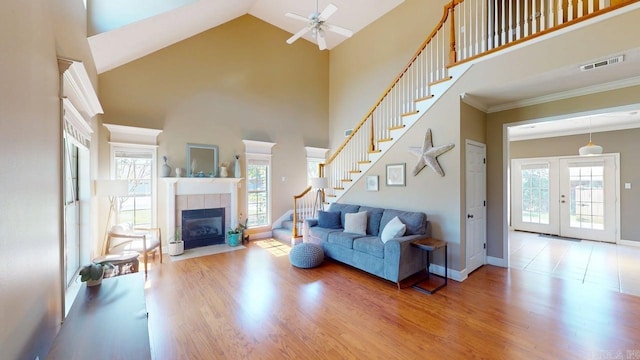 3805 Irby Dr, Conway, AR 72034 - living room with stairs, wood finished floors, ceiling fan, high vaulted ceiling, and a tiled fireplace
