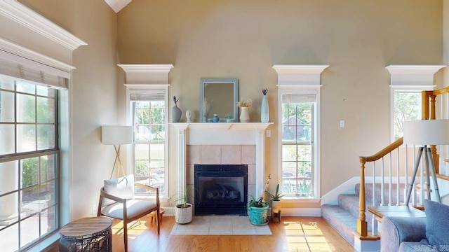 3805 Irby Dr, Conway, AR 72034 - living room featuring a fireplace, stairway, wood finished floors, baseboards, and a towering ceiling