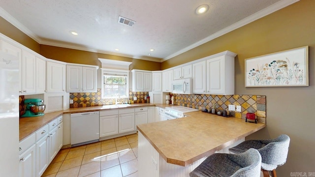 3805 Irby Dr, Conway, AR 72034 - kitchen featuring white appliances, a peninsula, a sink, white cabinets, and a breakfast bar area