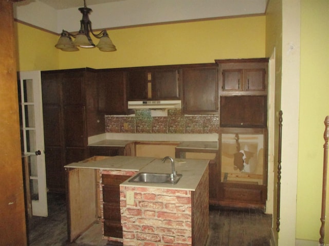 2111 S Arch St, Little Rock, AR 72206 - kitchen featuring a sink, tasteful backsplash, under cabinet range hood, hanging light fixtures, and a kitchen island