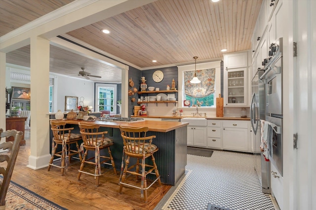 kitchen with wood counters, wood ceiling, a sink, recessed lighting, and white cabinets