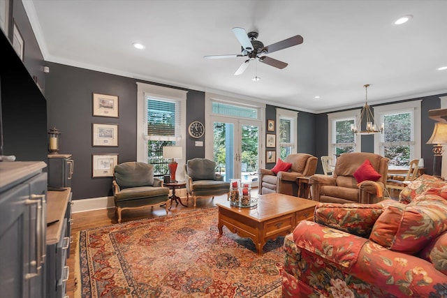 living area with ornamental molding, wood finished floors, a ceiling fan, recessed lighting, and baseboards