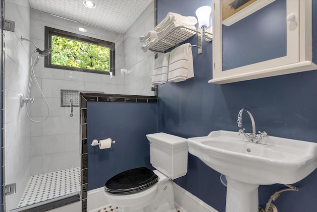 full bathroom with a shower stall, toilet, and baseboards