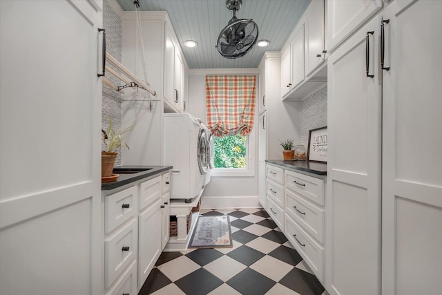laundry area featuring dark flooring, cabinet space, washer / clothes dryer, recessed lighting, and baseboards