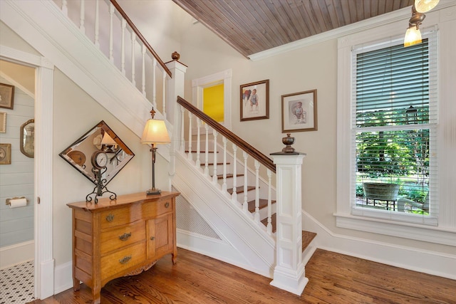 staircase featuring ornamental molding, wood finished floors, and baseboards