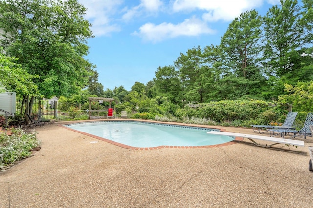 swimming pool with a patio area and a diving board