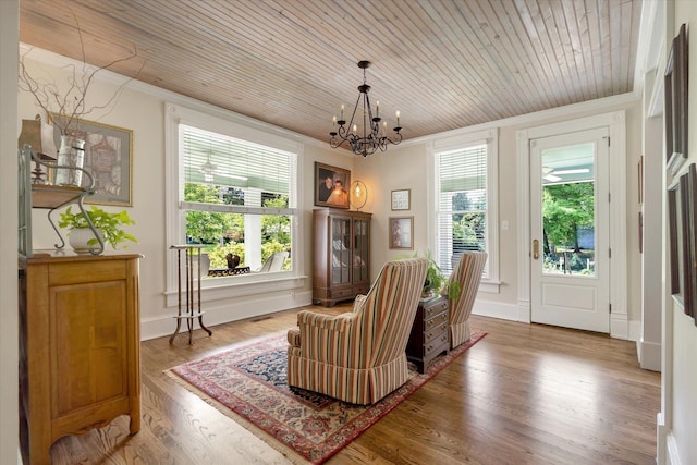 sitting room with plenty of natural light, a chandelier, crown molding, wooden ceiling, and wood finished floors
