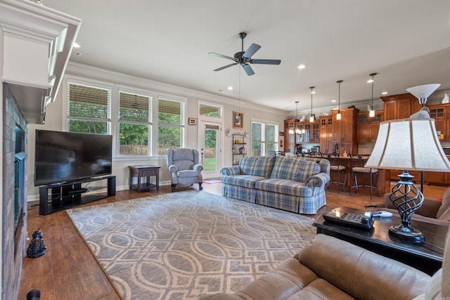 living room with a ceiling fan, wood finished floors, crown molding, recessed lighting, and baseboards