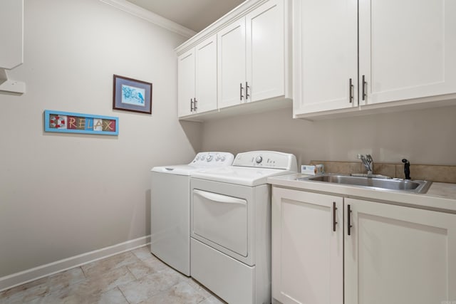 washroom with washing machine and dryer, cabinet space, baseboards, and ornamental molding