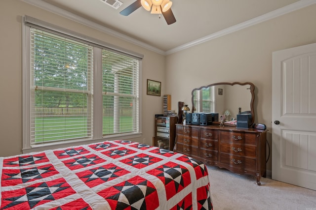 bedroom with multiple windows, carpet floors, ornamental molding, and a ceiling fan