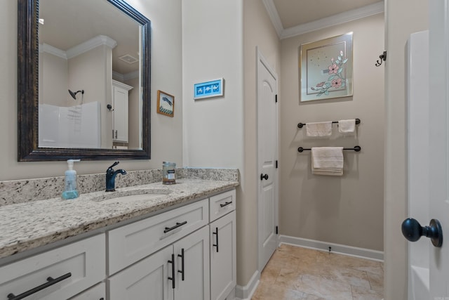 bathroom with ornamental molding, vanity, and baseboards