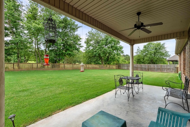 view of patio featuring a ceiling fan and view of wooded area