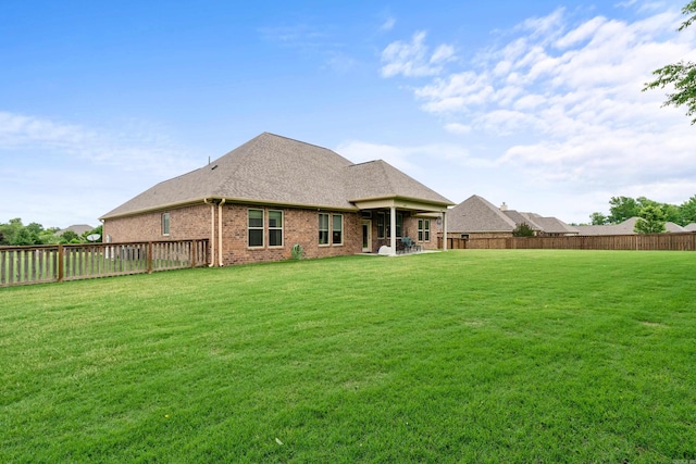 rear view of house with brick siding, a patio, and roof with shingles