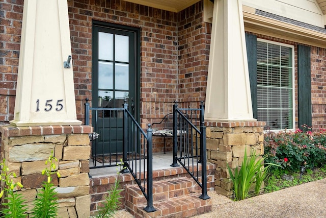doorway to property featuring brick siding