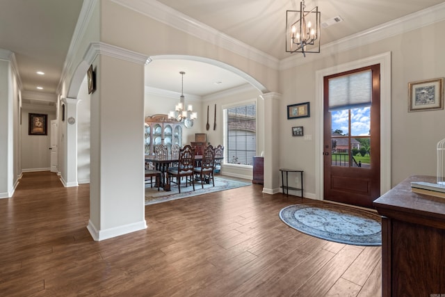 entryway featuring a chandelier, arched walkways, dark wood-style flooring, healthy amount of natural light, and ornamental molding