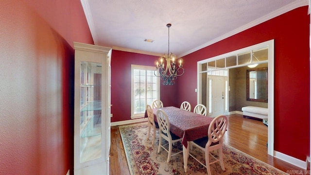 4335 Gazebo Dr, Conway, AR 72034 - dining space with wood finished floors, a chandelier, crown molding, baseboards, and french doors