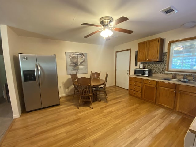 47 Eagle Ln, Mount Ida, AR 71957 - kitchen featuring appliances with stainless steel finishes, a sink, brown cabinetry, light wood-type flooring, and light countertops
