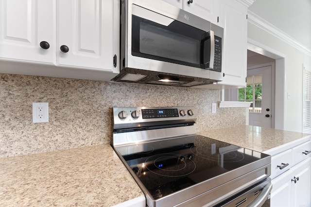 15 Alpine Ln, Cabot, AR 72023 - kitchen with appliances with stainless steel finishes, backsplash, light countertops, white cabinetry, and ornamental molding