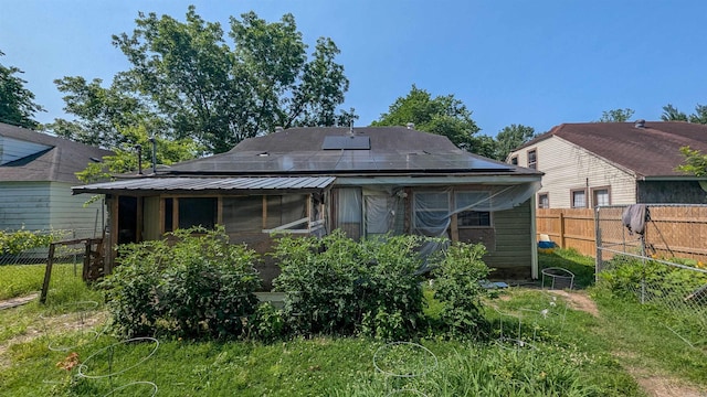 1407 Dill St, Newport, AR 72112 - rear view of property featuring solar panels and a fenced backyard