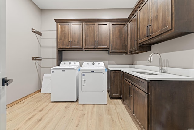 2634 Tannenbaum, Drasco, AR 72530 - laundry room featuring washing machine and clothes dryer, cabinet space, light wood-style flooring, and baseboards