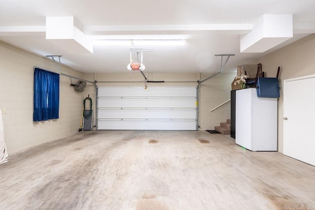 1244 N Scenic Dr, Heber Springs, AR 72543 - garage with concrete block wall, a garage door opener, and freestanding refrigerator