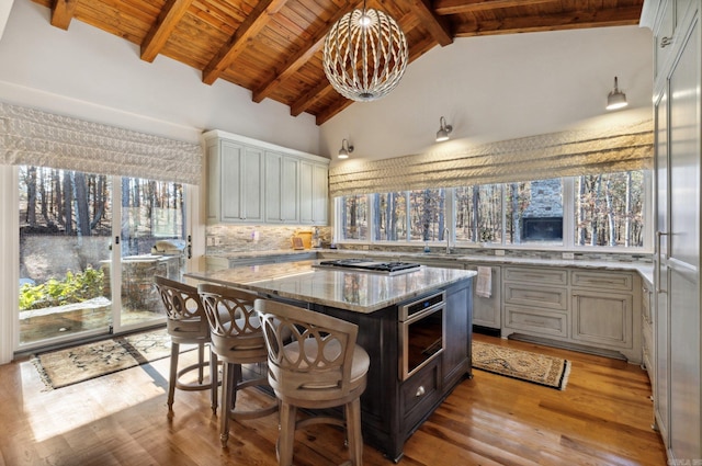 13200 Bart Moreland Dr, Roland, AR 72135 - kitchen featuring wooden ceiling, light stone counters, light wood-style flooring, plenty of natural light, and a kitchen breakfast bar