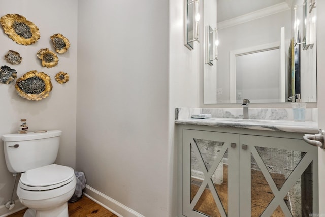 13200 Bart Moreland Dr, Roland, AR 72135 - bathroom with baseboards, toilet, vanity, ornamental molding, and wood finished floors