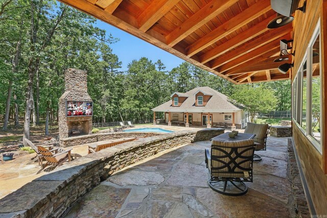 13200 Bart Moreland Dr, Roland, AR 72135 - view of patio / terrace featuring an exterior structure, an outdoor stone fireplace, an outdoor structure, and view of wooded area
