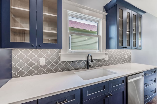 1908 S Gaines St, Little Rock, AR 72206 - kitchen with stainless steel dishwasher, a sink, blue cabinetry, light countertops, and backsplash