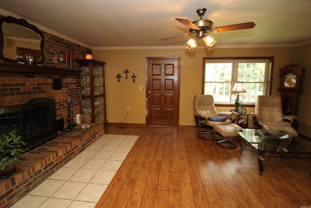 2102 N 22nd St, Paragould, AR 72450 - living area featuring light wood finished floors, a ceiling fan, a brick fireplace, crown molding, and baseboards