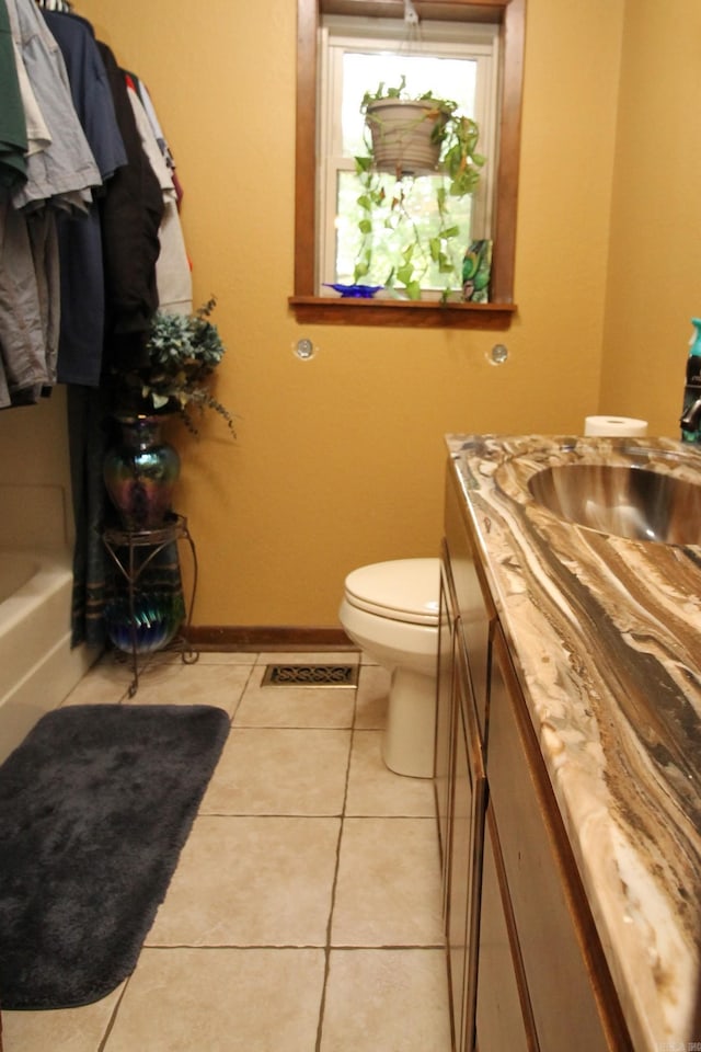 2102 N 22nd St, Paragould, AR 72450 - full bath featuring vanity, toilet, tile patterned floors, a bath, and baseboards