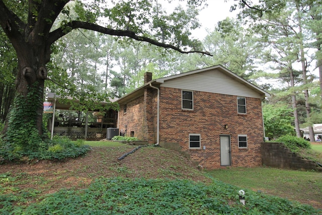 2102 N 22nd St, Paragould, AR 72450 - view of property exterior featuring central AC unit, a chimney, and brick siding