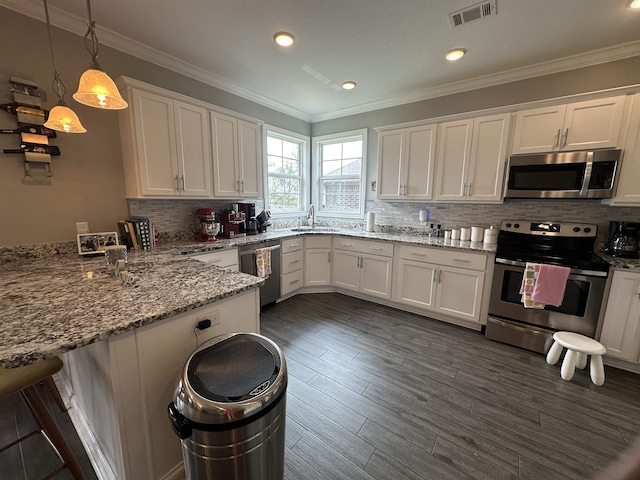 1008 Wildcat Ln, Jonesboro, AR 72405 - kitchen featuring appliances with stainless steel finishes, a sink, a peninsula, white cabinets, and backsplash