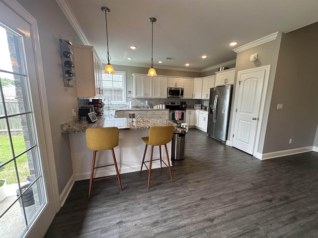 1008 Wildcat Ln, Jonesboro, AR 72405 - kitchen featuring stainless steel appliances, a peninsula, ornamental molding, decorative backsplash, and white cabinetry
