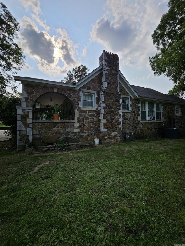 1421 W 25th St, North Little Rock, AR 72114 - view of side of home with stone siding, a lawn, and a chimney