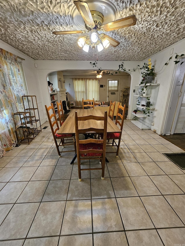 1421 W 25th St, North Little Rock, AR 72114 - dining space with arched walkways, a ceiling fan, and light tile patterned floors