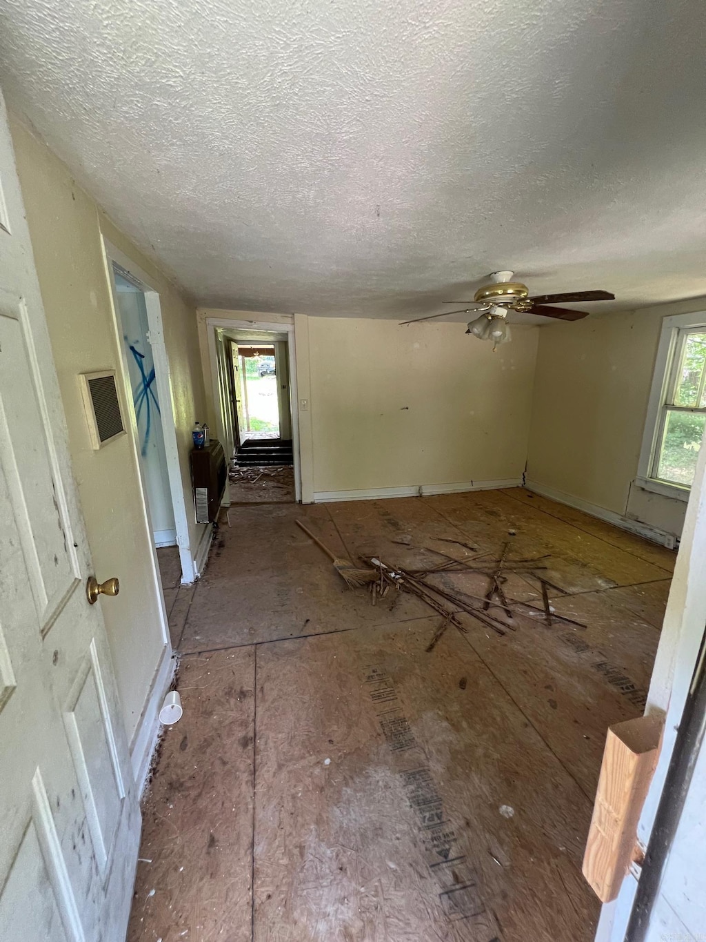 602 E Main, Flippin, AR 72634 - unfurnished living room with a textured ceiling and a ceiling fan