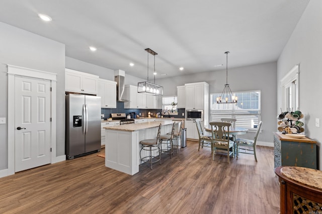 3069 Spring Mill Dr, Mountain Home, AR 72653 - kitchen featuring appliances with stainless steel finishes, wall chimney exhaust hood, a center island, a sink, and dark wood-type flooring